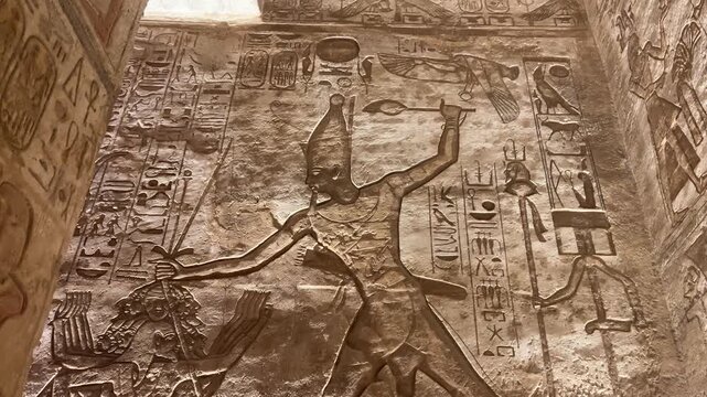Ancient relief at Abu Simbel showing Pharaoh smiting enemies with hieroglyphs.