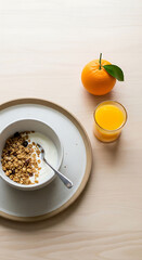 Cozy hygge breakfast with yogurt granola and fresh orange juice on a light table, lifestyle still life