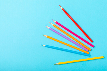 Colored pencils on a bright colored background. Equipment for coloring. Stationery for...