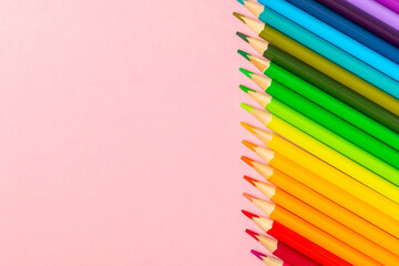 Colored pencils on a bright colored background. Equipment for coloring. Stationery for...