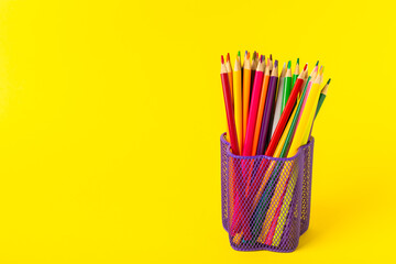 Colored pencils on a bright colored background. Equipment for coloring. Stationery for...