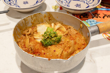 The tofu skin in the iron ladle on the table is used to dip the beef tongue
