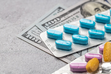 Dollar bill and a set of medicine pills. Rising costs of medical care. Reliefs for buying...
