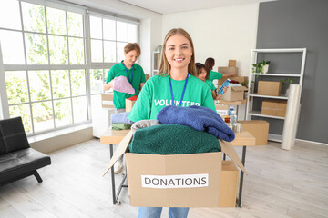 Young female volunteer with donations for poor people in center