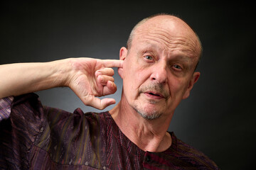 Closeup portrait of a senior man making funny faces