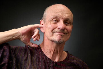 Obraz premium Closeup portrait of a senior man making funny faces