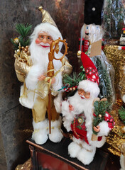 A Christmas toy in the form of Santa Claus with a white beard and glasses, wearing a hat and coat.  The atmosphere of celebration, comfort and winter fun. A holiday card for the New Year holiday.