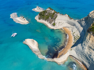 An aerial view of Cape Drastis in Corfu, Greece, showcasing stunning turquoise waters, dramatic...