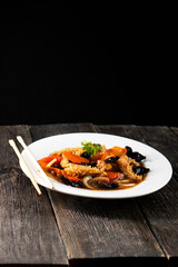 squid with vegetables on dark background. Asian food. Chinese cuisine. Seafood. Vegetables
