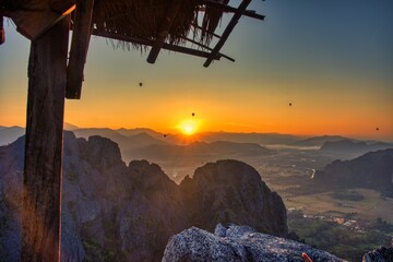 Breathtaking Stunning Sunset Over Mountain Ranges with a Cozy Rustic Shelter Awaiting Nature Enthusiasts