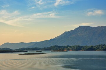 Peaceful Fisherboat on Nam Ngum Reservoir Surrounded by Mountains near Vang Vieng, Laos at Sunrise