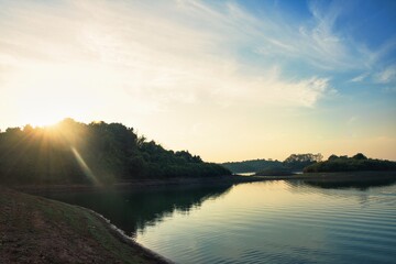 A Beautiful River Sunset, Bathed in Natural Light, Surrounded by Lush Greenery and Peaceful Reflections