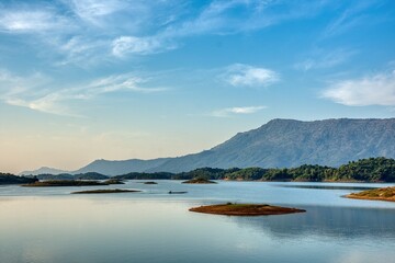Peaceful Fisherboat on Nam Ngum Reservoir Surrounded by Mountains near Vang Vieng, Laos at Sunrise