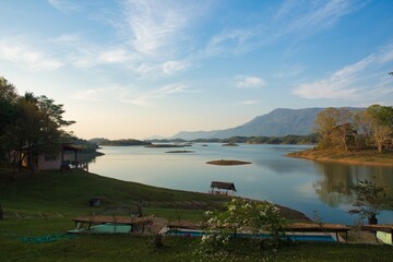 A serene lakeside view showcases majestic mountains surrounded by lush greenery and peaceful nature