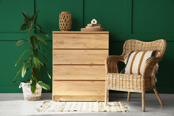 Interior of stylish living room with cozy wicker armchair, chest of drawers and houseplant