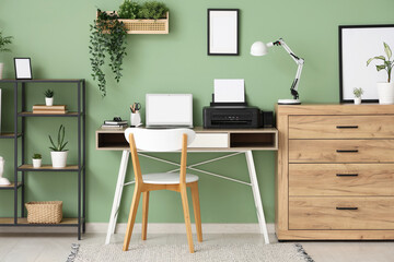 Workplace with modern printer, laptop and desk lamp in stylish home office