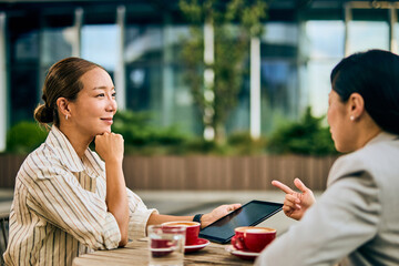 Asian Businesswomen Discussing Ideas Outside Modern Office Building