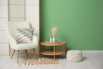 Interior of modern room with folding screen, armchair and table