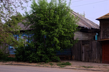 Charming wooden houses nestle together in rustic rural neighborhood, their weathered siding and...