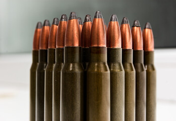 Ammunition lines up neatly showcasing full metal jacket rifle bullets with copper-colored tips and...