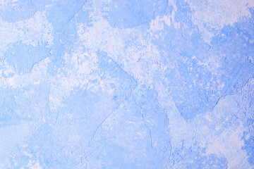 Blue textured plaster wall with abstract paint pattern