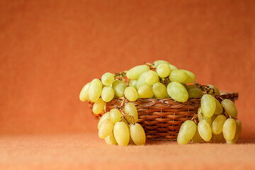 Fresh green grapes in a rustic wicker basket, gently spilling onto the table, highlighting their vibrant color and natural freshness. Perfect for healthy eating and farm-to-table.