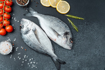 Top view of raw dorado fish with lemon pepper and rosemary on black background