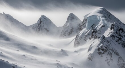 Snowy mountain peaks under a cloudy sky with blowing snow and wind creating a dramatic winter scene