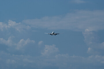 Airplane in the cloudy sky. An approaching airplane against a backdrop of clouds.