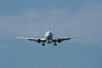 Airplane in the cloudy sky. An approaching airplane against a backdrop of clouds.