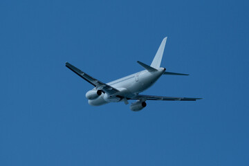 Airplane in the blue sky, close-up view of the plane. Aircraft soaring through the clear sky, detailed view of the plane.