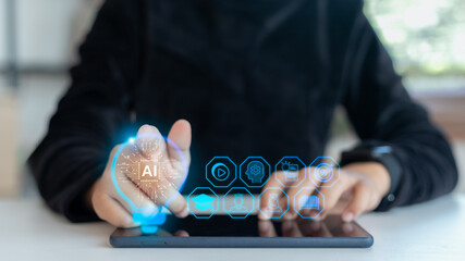 Close-up hand using a tablet with a hologram AI icon and digital education interface. Concept of artificial intelligence, e-learning, online study, smart learning platform, and innovative technology.