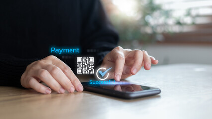 Close-up hand using a smartphone showing QR code payment with a success check mark. Concept of digital transaction, mobile banking, fintech, cashless society, secure online shopping, and e-commerce.