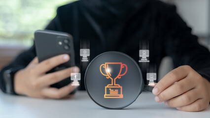 Hand holding hologram trophy icon with online learning features such as video lessons, audio books, and certification. Concept of e-learning success, educational achievement, and digital study.