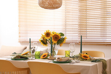 Elegant table serving with plates, candles and beautiful sunflowers