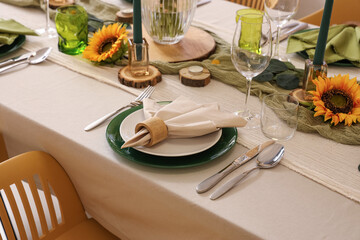 Elegant table serving with plates, folded napkin and beautiful sunflowers