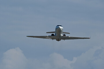 Airplane in the cloudy sky. The plane gaining altitude after takeoff from the airport.