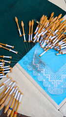 Bobbin Lace Crafting with Pins and Wooden Tools on Fabric Surface