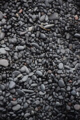Shiny wet black pebbles on beach
