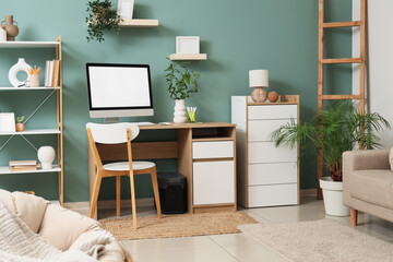 Interior of stylish living room with grey sofa, comfortable workspace, modern computer and...
