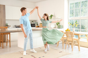 Young couple dancing in kitchen