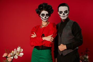 Couple enjoying Dia de los Muertos with sugar skull artistry and traditional attire