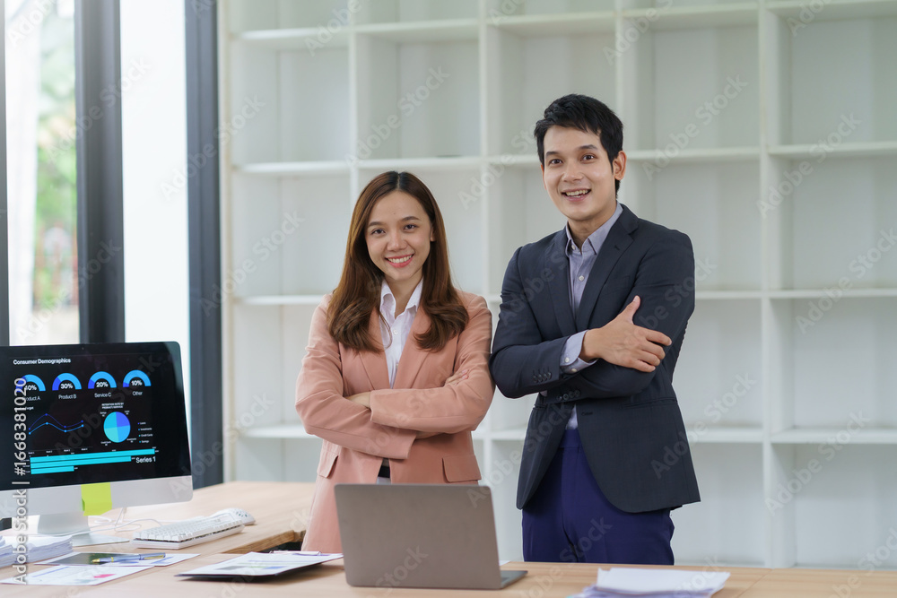 Aufkleber two young entrepreneurs smiling with arms crossed, standing in a modern office in front of a compute