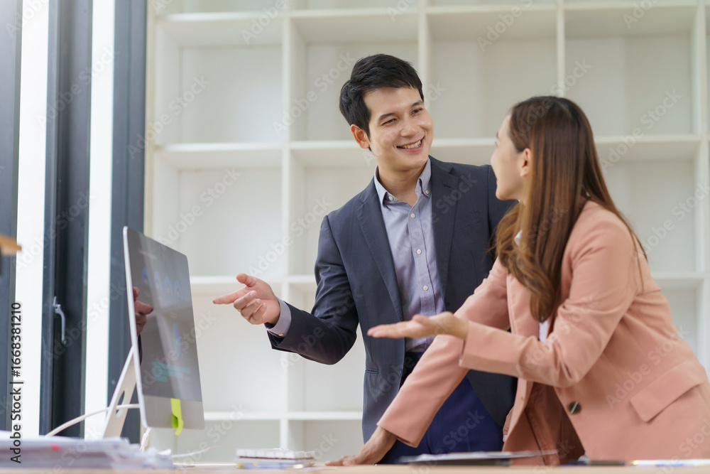 Aufkleber two asian businesspeople discussing work in a bright office, collaborating while analyzing data on a