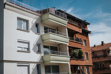 Modern urban apartment buildings with balconies against a clear blue sky, showcasing contemporary...
