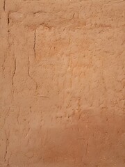 textured surface of dry cracked clay or mud wall with small fissures and rustic aged appearance
