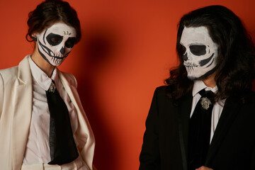 Couple honours Dia de los Muertos with traditional sugar skull face paint and elegant attire