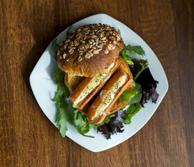 Top Down View of Gourmet Hot Dog with Frankfurter Würstchen Sausage and Welsh Cheddar Cheese on Whole Wheat Bun and Green Summer Salad
