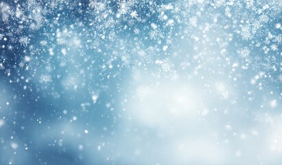 Fototapeta premium Falling snowflakes on a softly blurred, cool-toned blue background, creating a dreamy, wintery scene