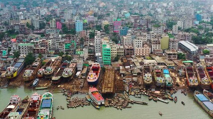 Dhaka, Bangladesh - 23 August 2025: Aerial view of numerous boats docked near buildings, creating a vibrant contrast of maritime and urban landscapes.